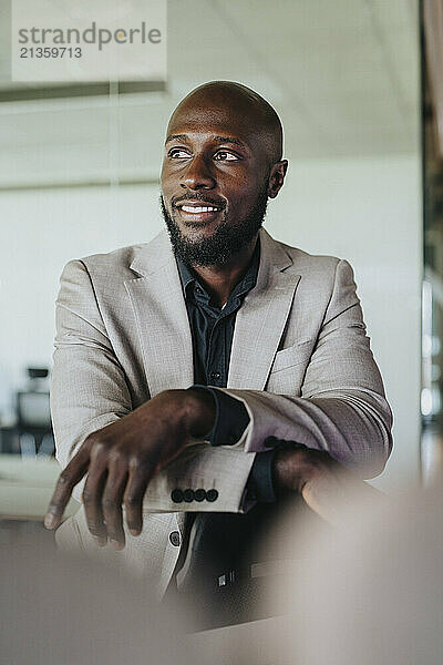 Smiling bald businessman standing in office