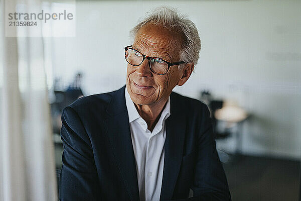 Senior businessman wearing eyeglasses looking away