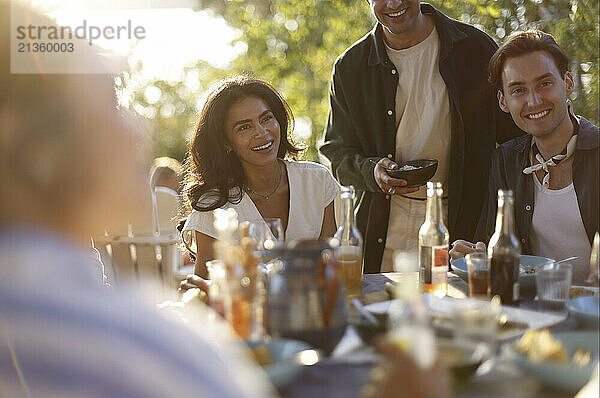 Group of happy friends enjoying together during dinner party in back yard