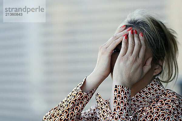 Woman covering her face with her hand. Depression.