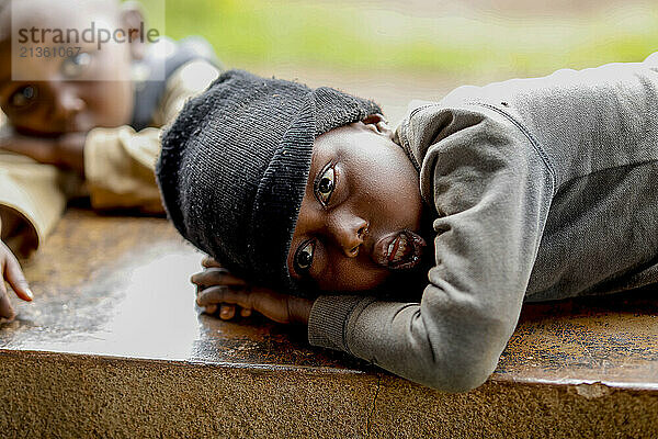 Boys lying on a wall in southern Rwanda