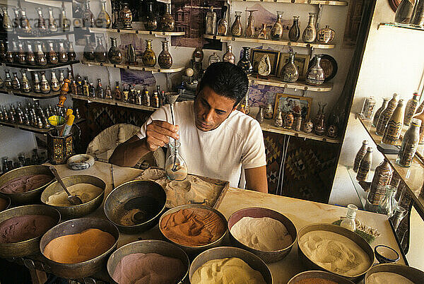 Ma working with colored sands used for making decorative bottles  Jordan  Middle East