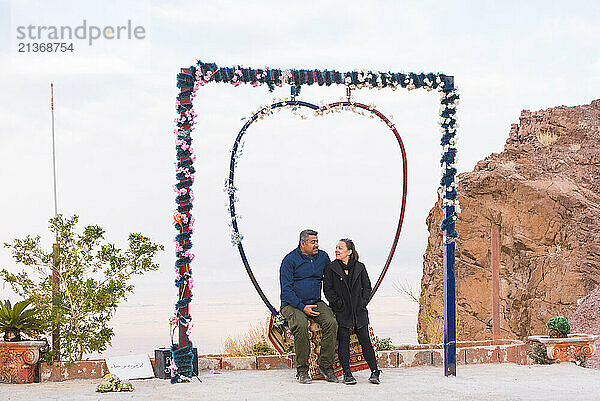 Couple sitting on a heart-shaped swing  Jordan  Middle East