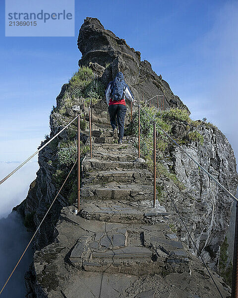 Tourist walks the trail above the clouds at Pico do Areeiro  a high altitude hiking destination on the island of Madeira  Portugal; Sao Roque do Faial  Madeira  Portugal