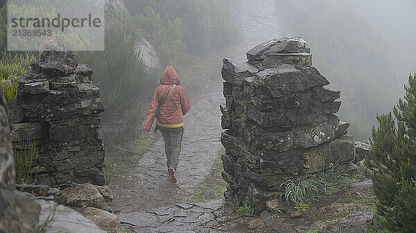 Female tourist on the trail in the fog at the highest peak  Pico Ruivo  on the island of Madeira  Portugal; Ilha  Madeira  Portugal