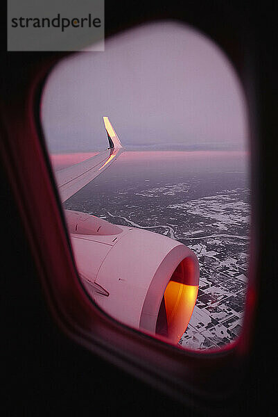 View of the sunrise from an airplane window in winter