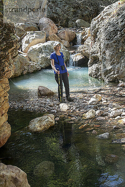 Portrait of a female hiker smiling while standing by a pool in the South Fork of Cave Creek in the Chiricahua Mountains of Southeast Arizona; Arizona  United States of America