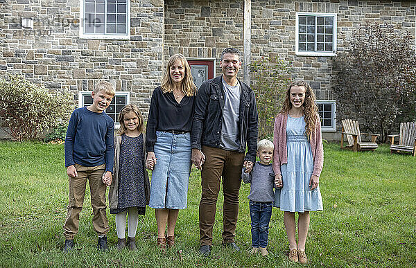 Portrait of a family standing in front of their house in Beckwith Township at Carleton Place in the Ottawa Valley; Ontario  Canada