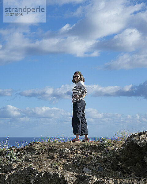 Woman stands at the Sao Sebastiao viewpoint along the North Atlantic ocean on the island of Madeira  Portugal; Ribeira Brava  Madeira  Portugal