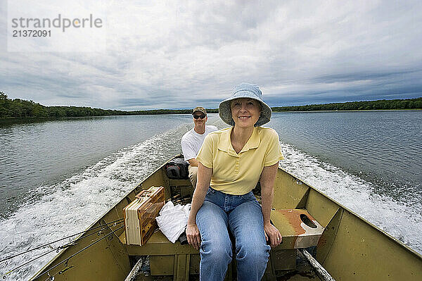 Man and woman enjoy a boat ride across a lake  near Crosslake  Minnesota  USA; Minnesota  United States of America