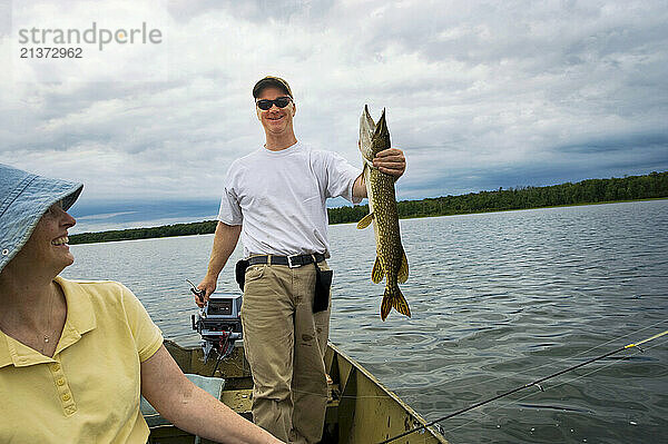 Man shows off a fish caught while fishing on a lake  near Crosslake  Minnesota  USA; Minnesota  United States of America