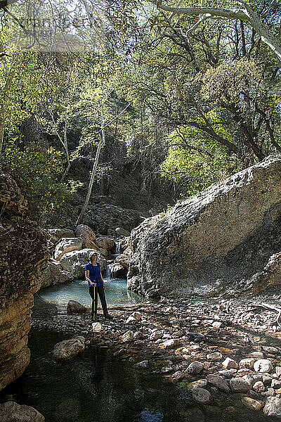 Portrait of a female hiker smiling at the camera while standing by a pool in the South Fork of Cave Creek in the Chiricahua Mountains of Southeast Arizona; Arizona  United States of America