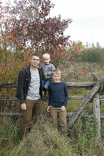 Portrait of a father posing with his two sons in a fall  rural setting  Beckwith Township at Carleton Place in the Ottawa Valley; Ontario  Canada