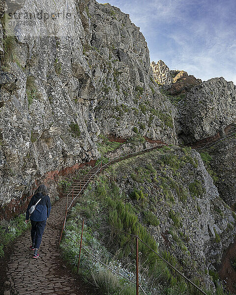 Female tourist walks the trail at Pico do Areeiro  a high altitude hiking destination on the island of Madeira  Portugal; Sao Roque do Faial  Madeira  Portugal