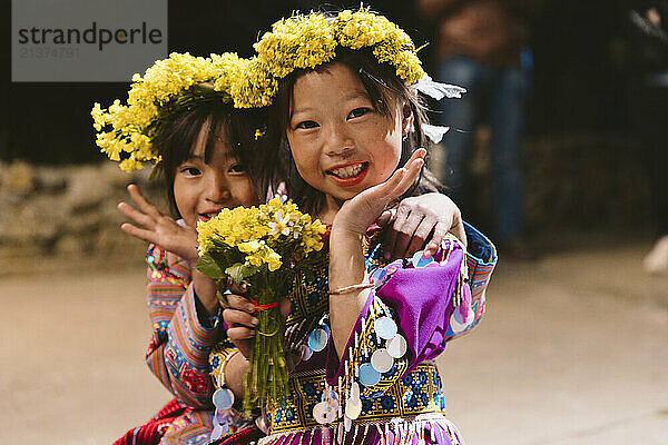 Hmong girls with floral garland on their heads  posing for the camera; Pa Co  Mai Chau  Son La  Vietnam