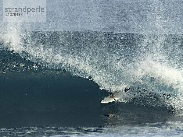 Pipeline surfer under the wave curl and spray  off the North shore of the island of Oahu; Oahu  Hawaii  United States of America