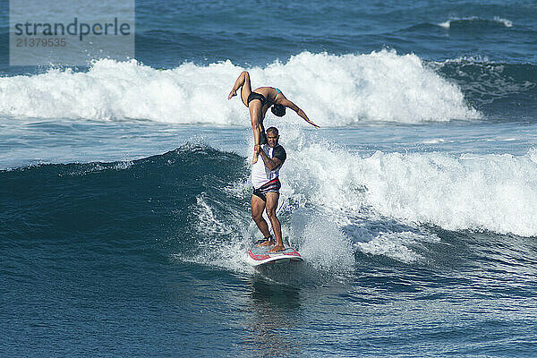 Tandem surfers in a surf competition at Makaha Beach on the island of Oahu  Hawaii  USA; Makaha  Oahu  Hawaii  United States of America