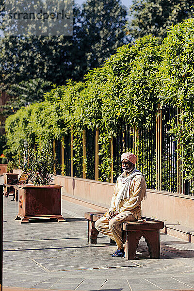 Mature man with a turban sits enjoying the warm sun in India; Amritsar  Punjab  India