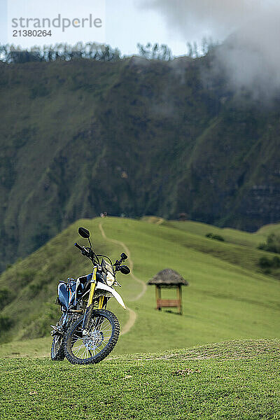 Motorbike parked along a path on a ridge overlooking a rugged mountainside  South Sulawesi  Indonesia; Lembah Ollon  Bonggakaradeng  Tana Toraja Regency  South Sulawesi  Indonesia