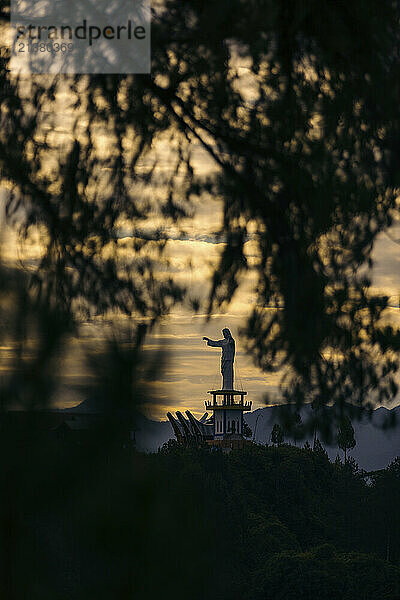 Statue of Jesus Christ under a glowing sky at sunset at Wisata Religi BUKIT DOA Toraja Utara  a religious tourist attraction in South Sulawesi  Indonesia; Kapala Pitu  North Toraja Regency  South Sulawesi  Indonesia