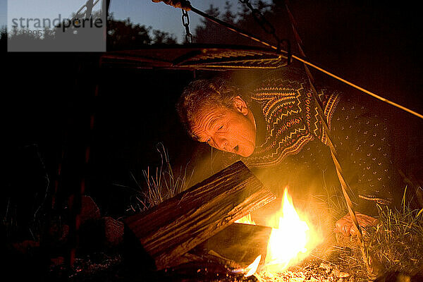 A man lights a campfire in Denmark.