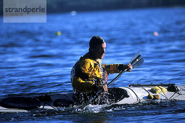 A man performs an eskimo roll in his sea kayak near Thief Island on Muscungus Bay  Maine. (releasecode: DM_MR1032)