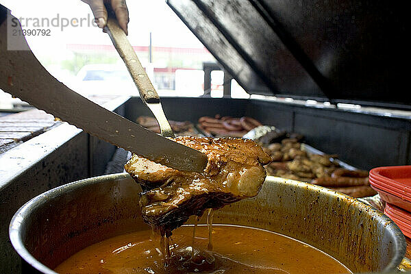 A beef brisket begin dipped in special sauce at Cooper’s Old-Time Pit Barbeque in Llano  Texas. Cooper’s Old-Time Pit Bar-B-Que
604 West Young Street
Llano  TX 325-247-5713