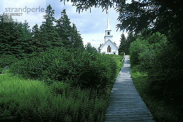 A wooden boardwalk leads to a church at the top of a hill on Isle au Haut  Maine.