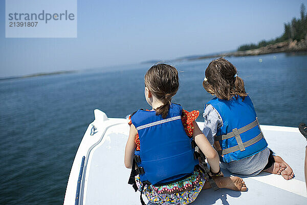 Two friends take a ride on a lobster boat during an annual family vacation on Swan's Island  maine.