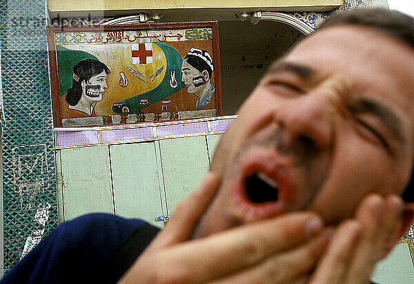 A man holds his jaw in pain after a trip to the dentist in Kashkar  a city in far western China. (releasecode: DM_MR1047)