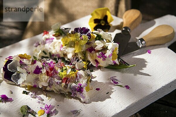 Presentation of goat cheese rolls with edible flowers