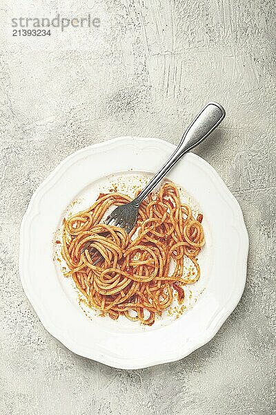 A plate with leftover spaghetti bolognese  no people