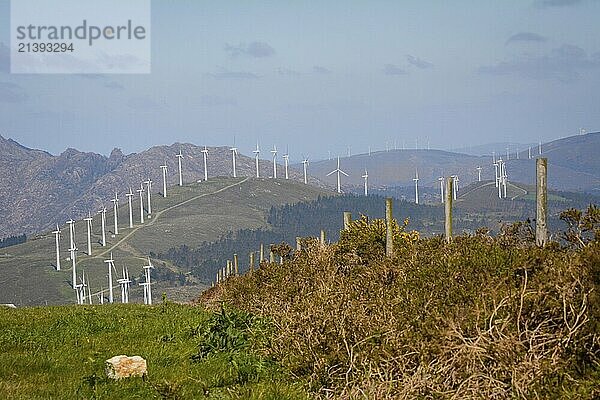 Landscape with lined up wind turbines of a wind farm on a mountain rig. Sustainable energy