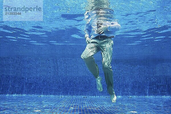 Low angle of businessman's legs underwater