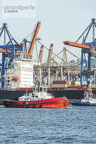 Closeup of the Hamburg harbor with container terminal and tug in the foreground