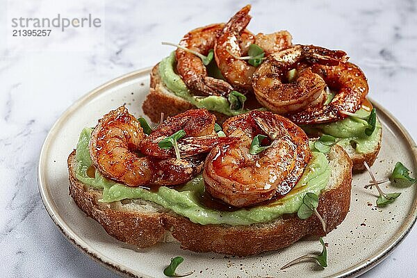 Sandwiches with avocado and caramelized shrimp  micro-greens  breakfast  on a plate  top view  homemade  no people