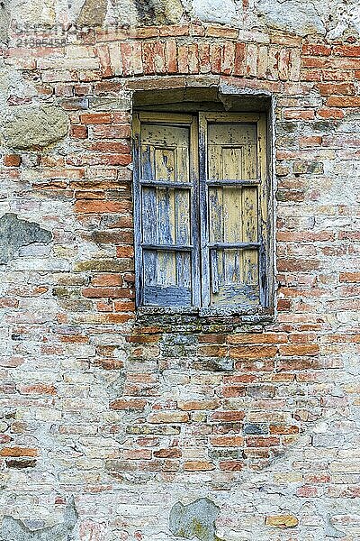 Old weathered window on a brick wall