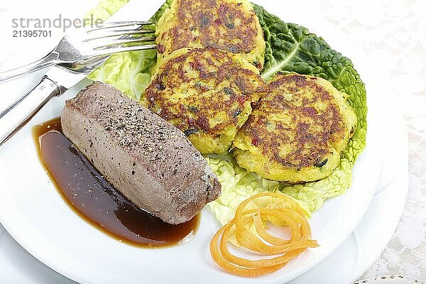 Swabian cuisine  medallions of wild boar with savoy cabbage cakes  meat dish  roasted  hearty  home cooking  typical Swabian  arranged on a plate  traditional cuisine reinterpreted  food photography  studio  Germany  Europe