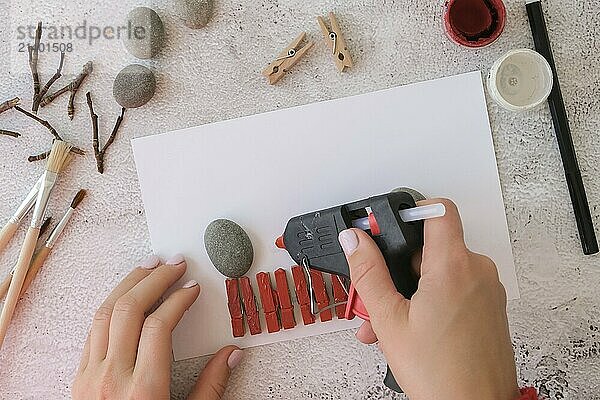 Diy Merry Christmas deer on greeting card postcard made of pebbles  sea stones  clothespins and branches on white background. Natural Eco style diy. Gift idea. Step by step. Top view. Process kid children craft. Do it yourself