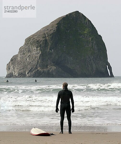 Man looks out assessing the situation on a Pacific Ocean Beach