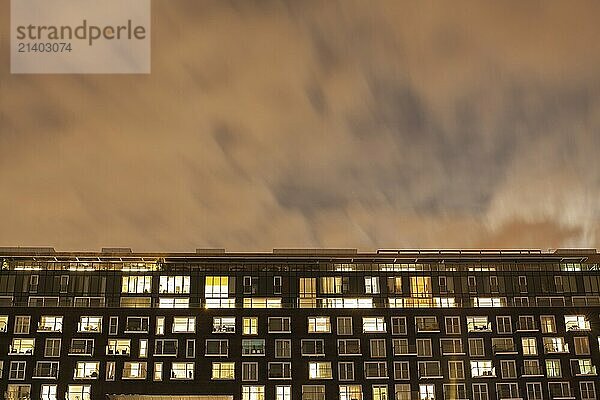 The exterior of a modern apartment building at night