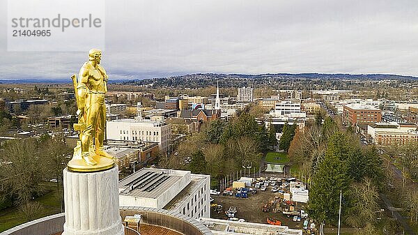 The state capital building adorned with the Oregon Pioneer with downtown Salem in the background