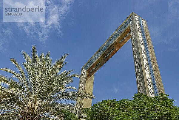 A picture of the Dubai Frame above the trees of the Zabeel Park