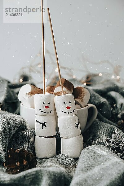 Two happy funny marshmallow snowmen. Marshmallow friends. Diy. Sweet treat for kids funny marshmallow snowman. Christmas winter holiday decoration. New year greeting card. Christmas lights. Cup of cacao