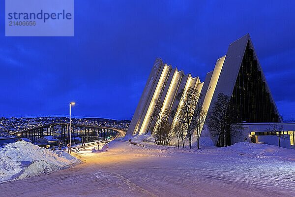 Illuminated Ishavskatedralen or Ice Sea Cathedral in winter  behind Tromsø Bridge  twilight  Tromsø  Troms  Norway  Europe