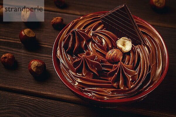 Chocolate nut paste  mousse  pasta  in a cup  on a wooden table  top view  selective focus  no people