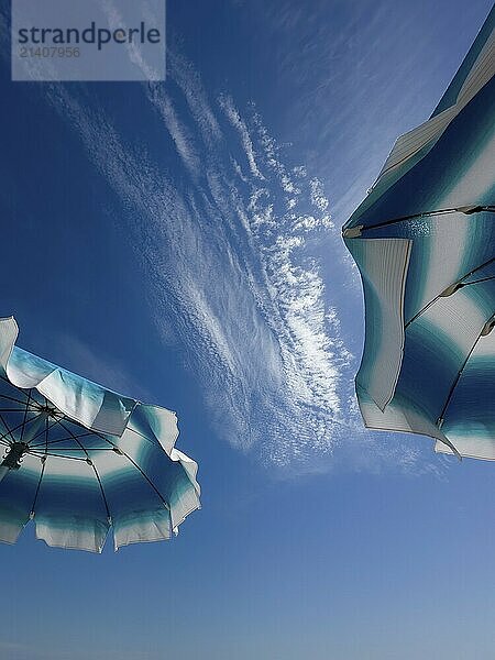 Parasols in front of a blue sky with clouds