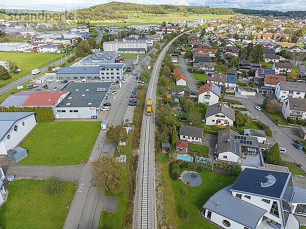 Aerial view of a railway track through a mixed area with residential and commercial buildings  tamping machine  Hermann Hessebahn  Althengstett  Black Forest  Germany  Europe