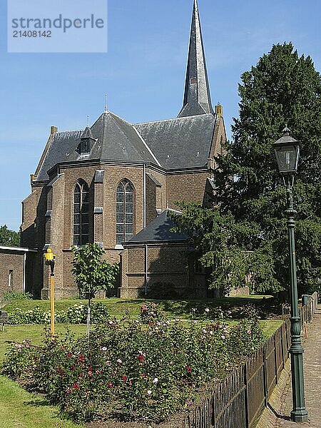 A large brick church with a high tower and a well-kept garden  bredevoort  achterhoek  the netherlands