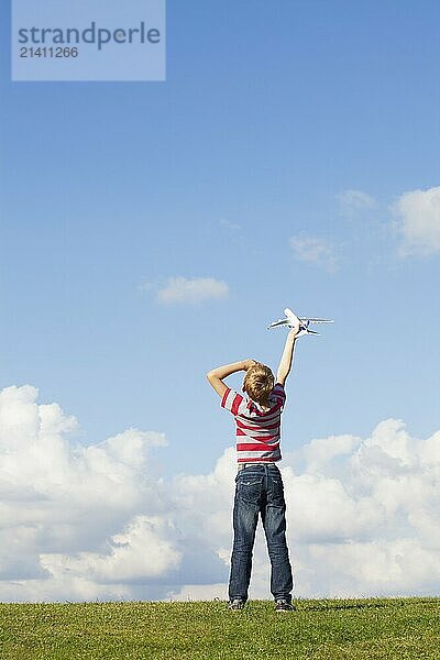 Pre teen caucasian boy holding model plane